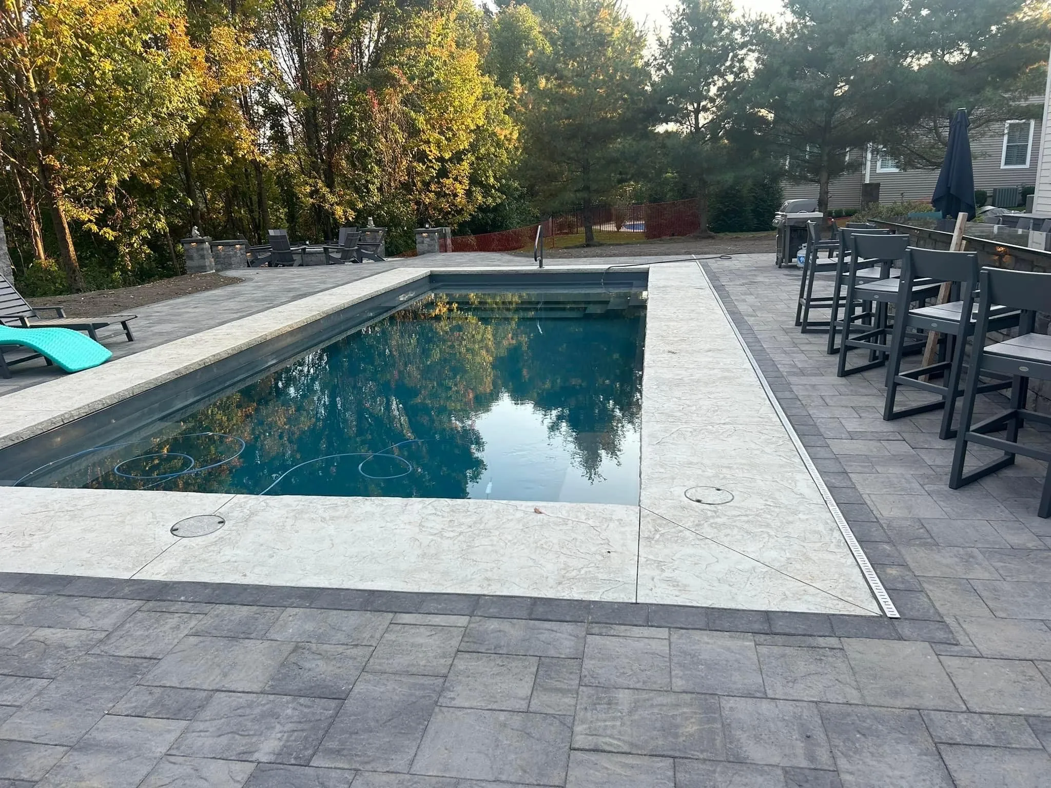 Full backyard landscape design Capital Region NY — pool, paver patio, outdoor living by Capital Land Companies in Waterford